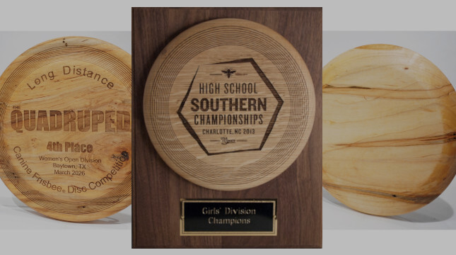 Three wood award trophies are shown. One is mounted on a plaque with a metal wording plate at the bottom. Two have been engraved with a design and wording, the other is blank.